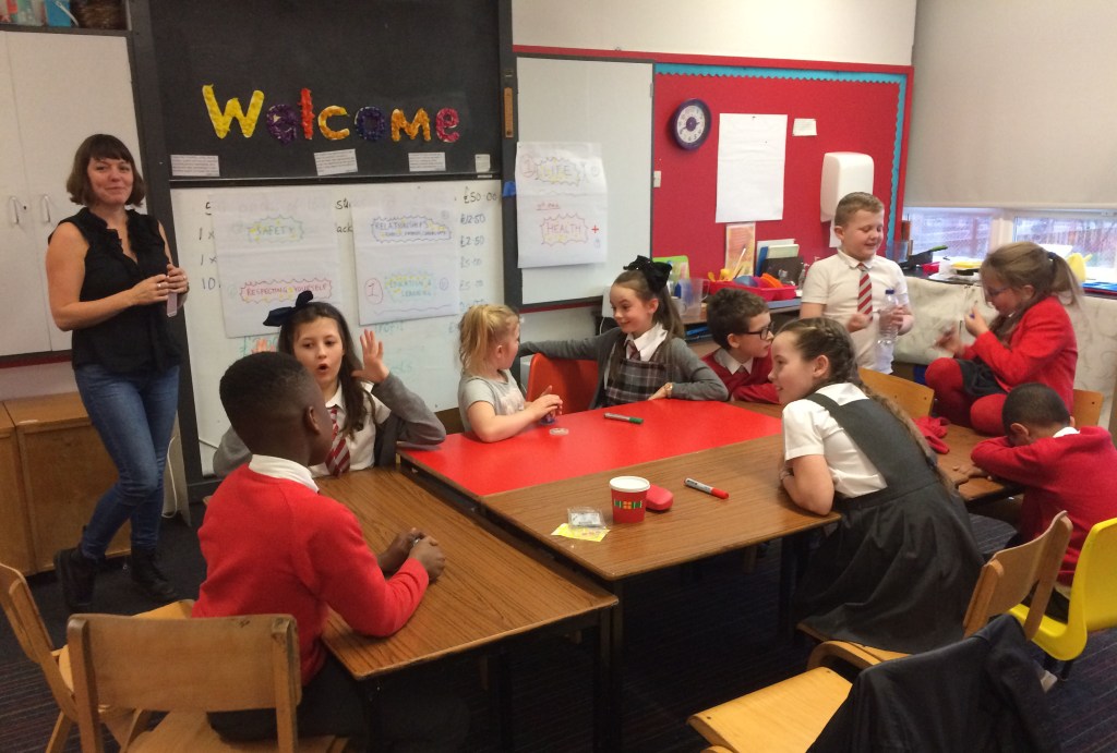 A researcher with a group of primary school children from the Bridgeton and Dalmarnock neighbourhood undertaking group work
