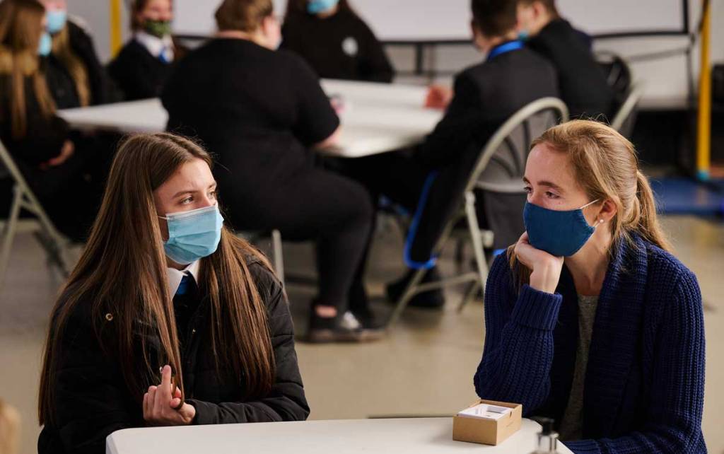 A school pupil chats with a local coordinator during partnership working session